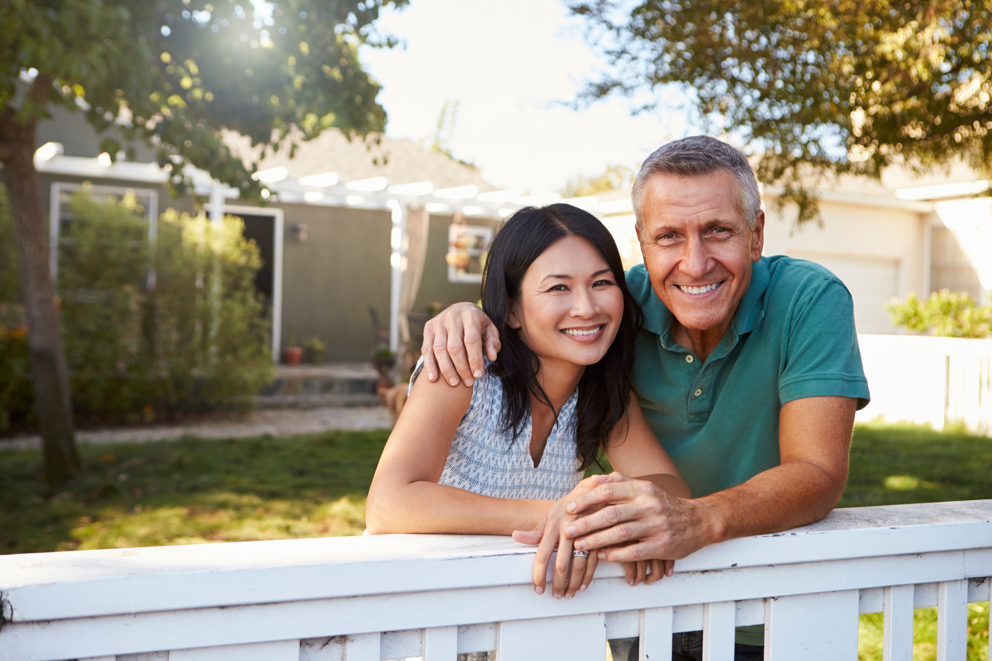 Mature Couple Looking over Back Yard Fence